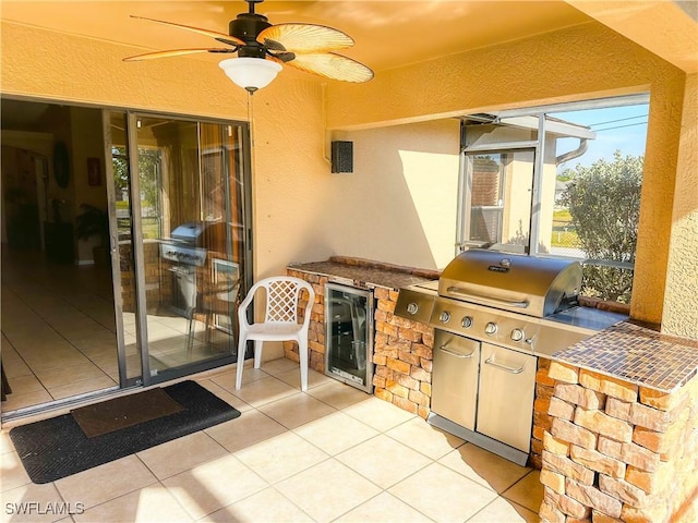 view of patio featuring exterior kitchen, ceiling fan, grilling area, and wine cooler