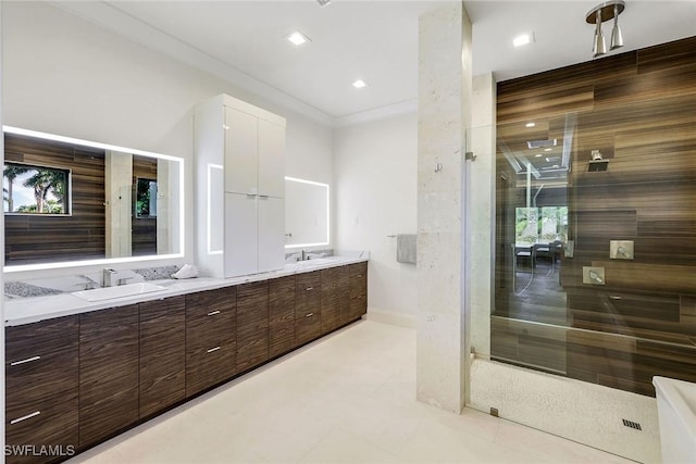 bathroom featuring tile patterned flooring, vanity, a tile shower, and ornamental molding