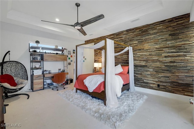 bedroom featuring a raised ceiling, ceiling fan, and concrete flooring