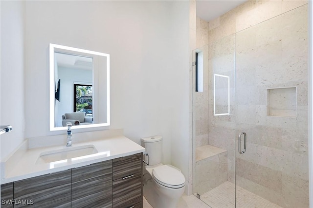 bathroom featuring vanity, toilet, and a shower with door