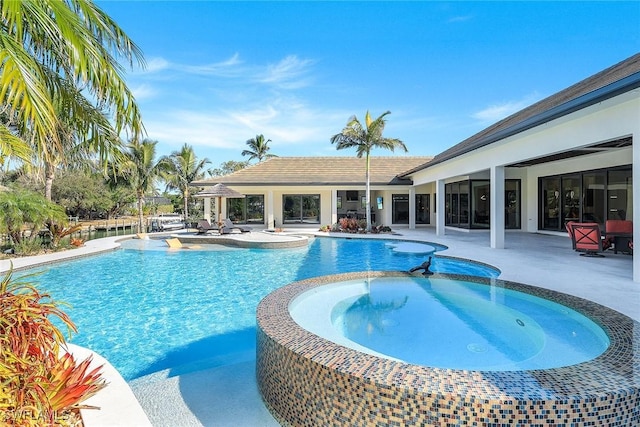 view of pool with an in ground hot tub and a patio area