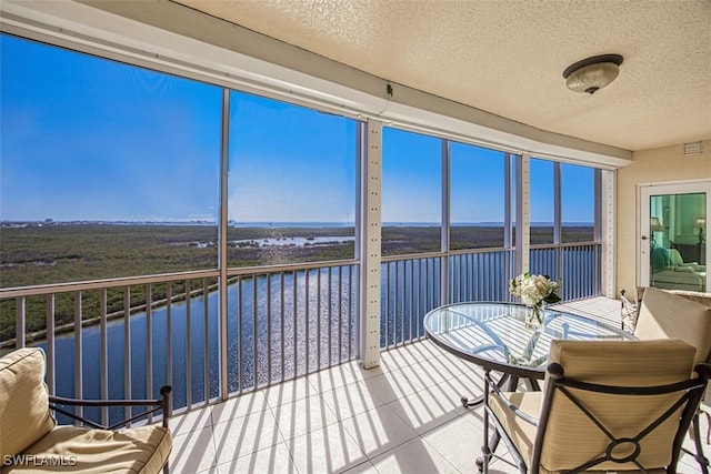 unfurnished sunroom with a water view