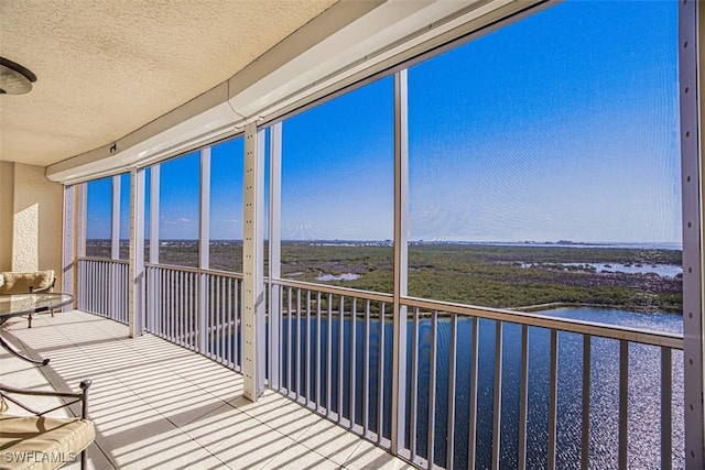 unfurnished sunroom featuring a water view