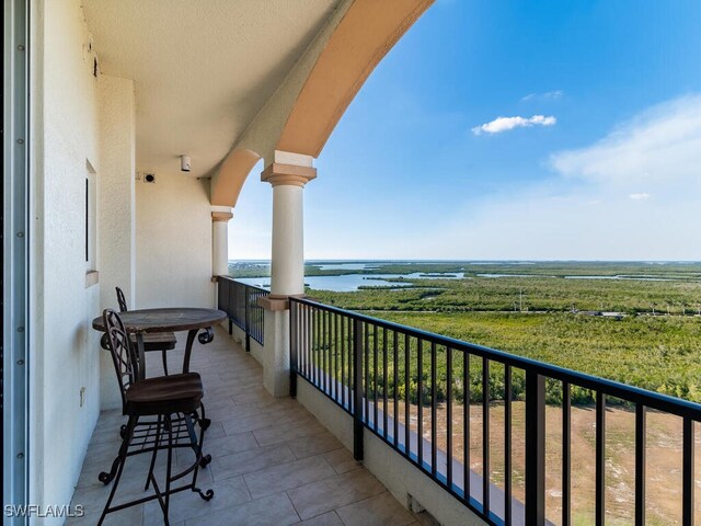 balcony featuring a rural view and a water view