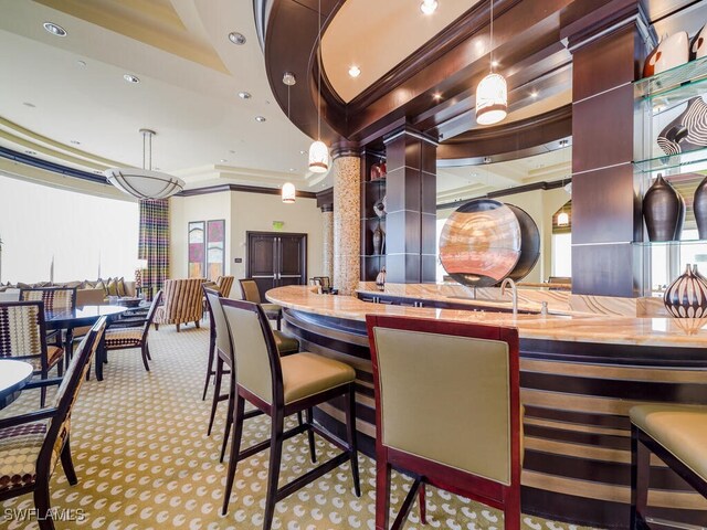 interior space with light carpet, ornamental molding, a wealth of natural light, butcher block countertops, and decorative light fixtures