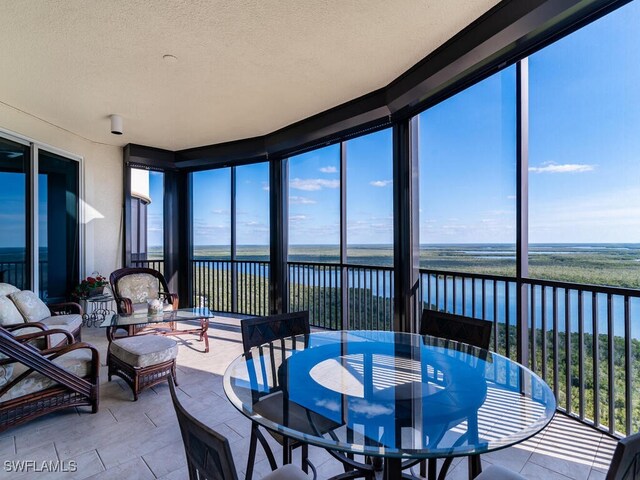 sunroom / solarium with a water view