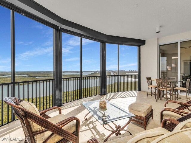 sunroom / solarium featuring a water view