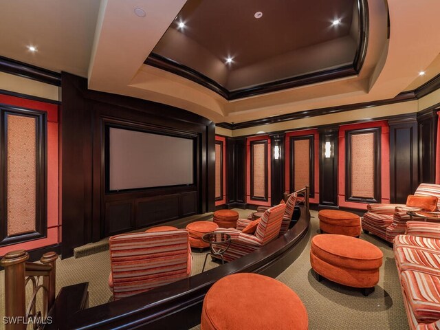 carpeted cinema room with a raised ceiling, ornate columns, and ornamental molding