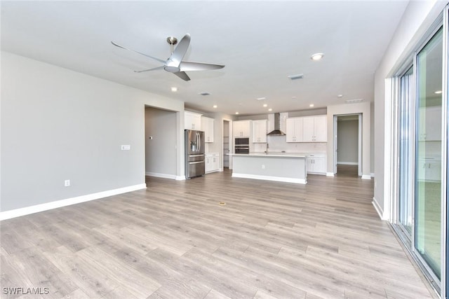 unfurnished living room with ceiling fan and light hardwood / wood-style floors