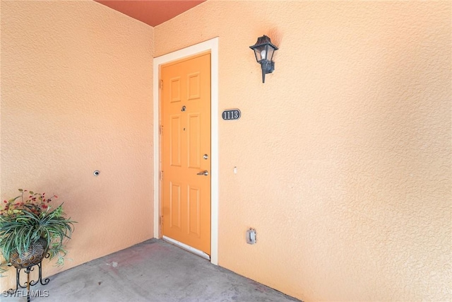 entrance to property featuring stucco siding