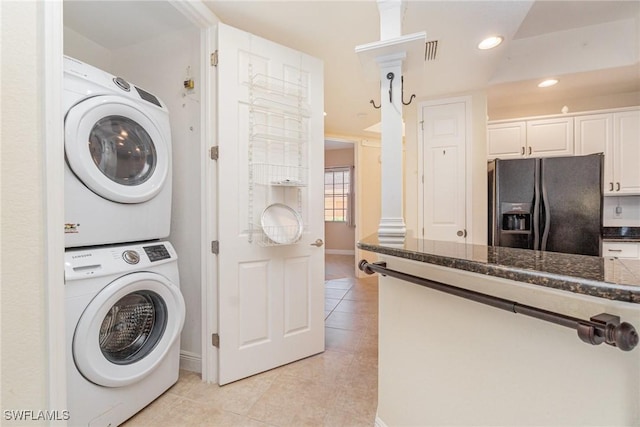 laundry room featuring light tile patterned floors, recessed lighting, laundry area, visible vents, and stacked washing maching and dryer