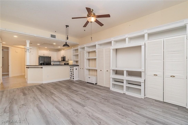 unfurnished living room with ceiling fan and light hardwood / wood-style flooring