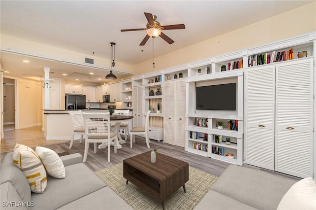 living room featuring light wood-type flooring and ceiling fan