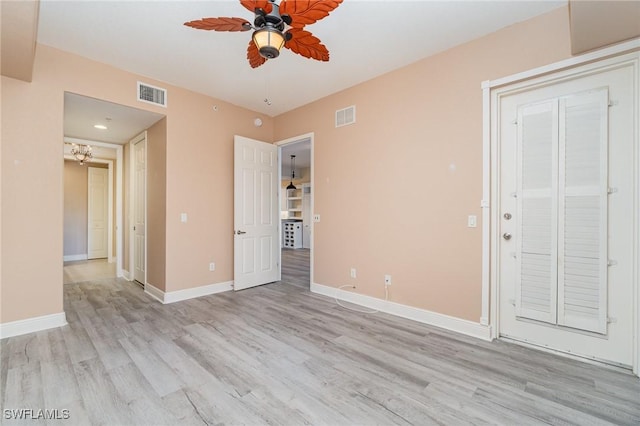 unfurnished room featuring light wood-style floors, visible vents, ceiling fan, and baseboards