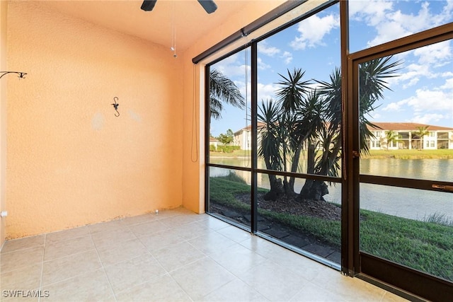 unfurnished sunroom featuring a water view and ceiling fan