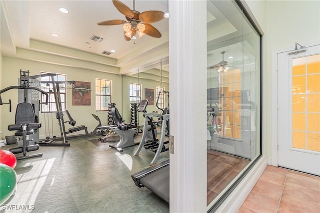 exercise room with recessed lighting, a raised ceiling, visible vents, and ceiling fan