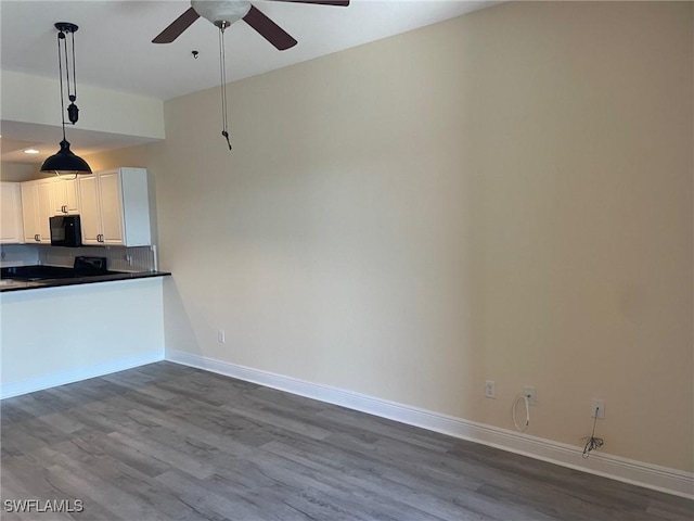 kitchen with black microwave, baseboards, dark countertops, dark wood finished floors, and decorative light fixtures