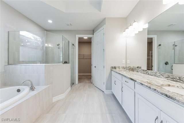 bathroom featuring tile patterned flooring, shower with separate bathtub, and vanity