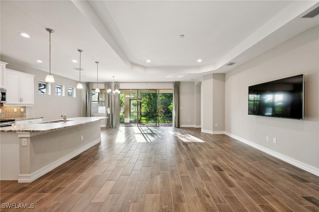 kitchen with dark hardwood / wood-style flooring, white cabinetry, and plenty of natural light