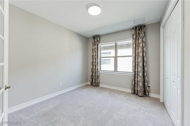 unfurnished bedroom with light carpet and a closet