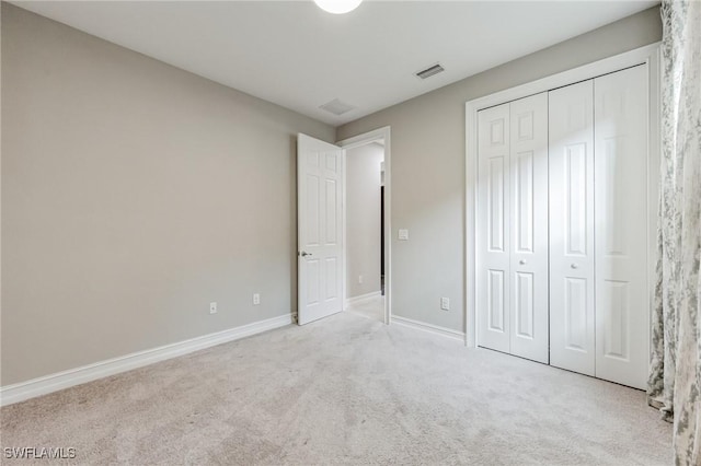 unfurnished bedroom featuring light colored carpet and a closet