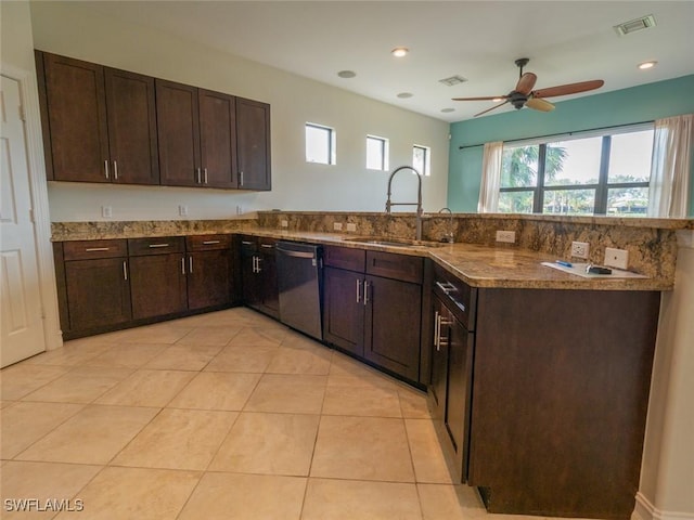 kitchen with dishwasher, sink, dark stone countertops, light tile patterned flooring, and dark brown cabinetry