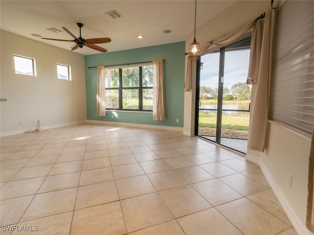 tiled empty room featuring a wealth of natural light and ceiling fan