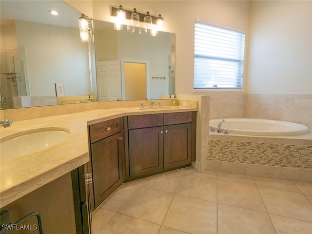 bathroom featuring tile patterned floors, vanity, and a relaxing tiled tub