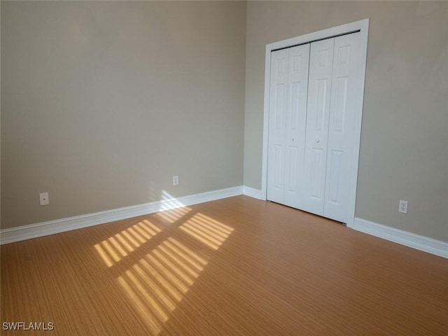 unfurnished bedroom with a closet and hardwood / wood-style flooring