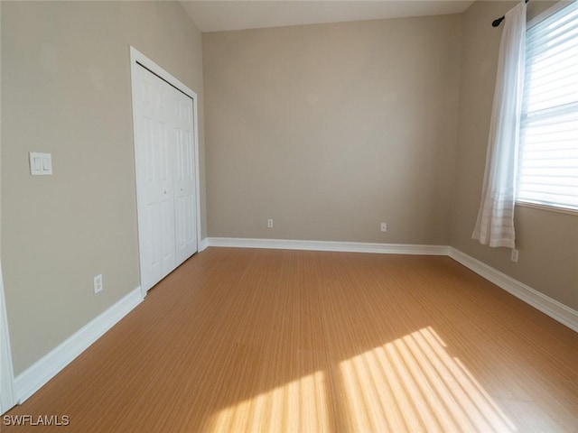 unfurnished bedroom with hardwood / wood-style flooring and a closet