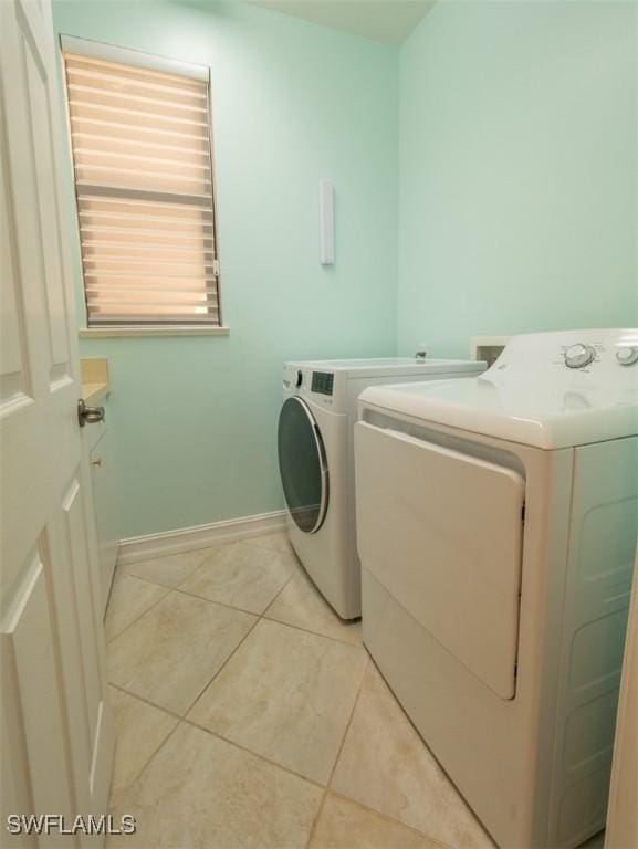 clothes washing area with light tile patterned flooring and washing machine and dryer