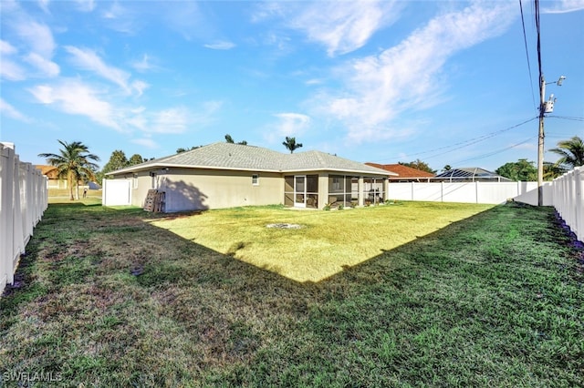 rear view of property with a sunroom and a lawn