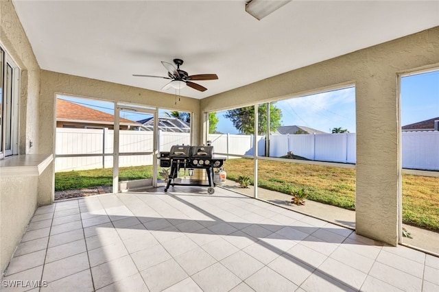 unfurnished sunroom featuring ceiling fan