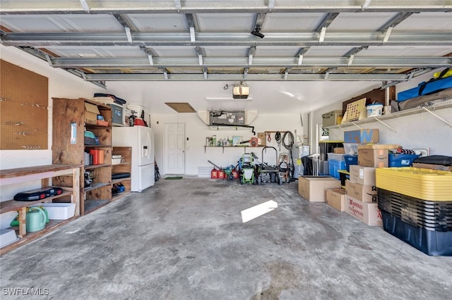 garage featuring a garage door opener and white refrigerator with ice dispenser