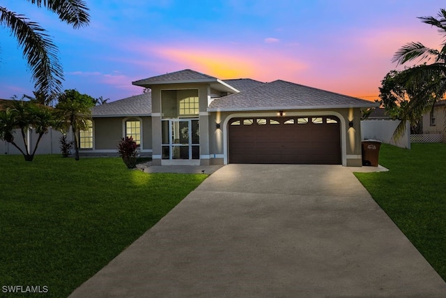 prairie-style home featuring a garage and a lawn