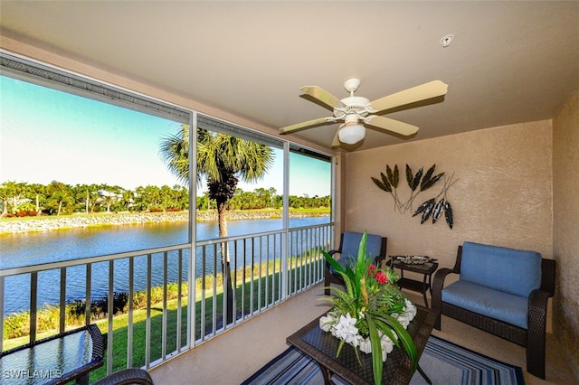 balcony with ceiling fan and a water view