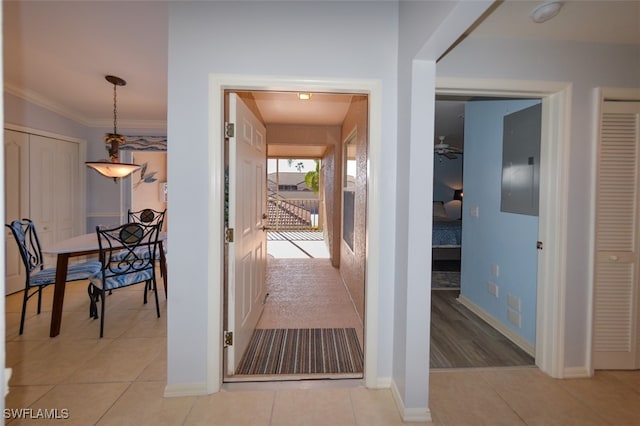 hall with ornamental molding and light tile patterned flooring