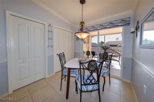 tiled dining space with crown molding and lofted ceiling