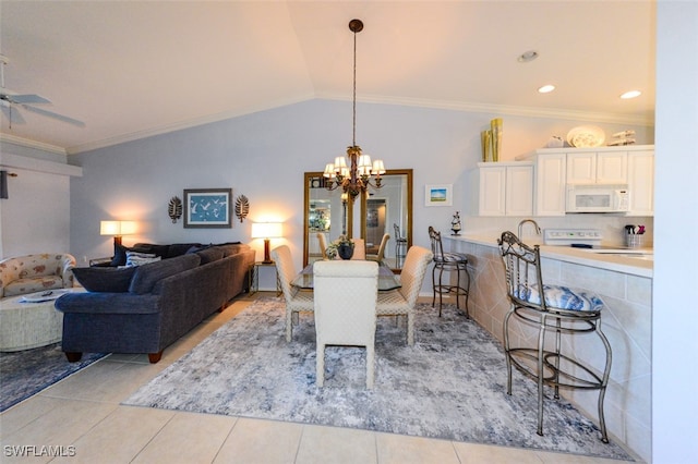 tiled dining area featuring ceiling fan with notable chandelier, vaulted ceiling, and ornamental molding