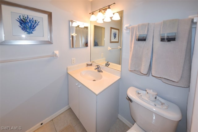 bathroom with toilet, vanity, and tile patterned floors