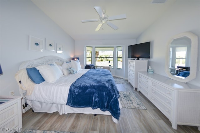 bedroom featuring multiple windows, light wood-type flooring, vaulted ceiling, and ceiling fan