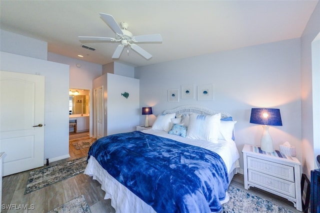 bedroom with hardwood / wood-style flooring, ensuite bath, and ceiling fan