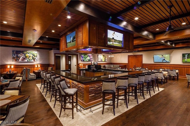 bar with wood walls, wooden ceiling, and hardwood / wood-style flooring