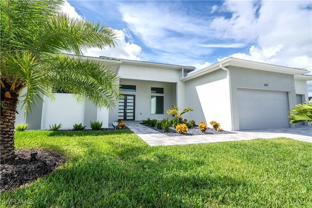 view of front facade with a garage, a front yard, and french doors