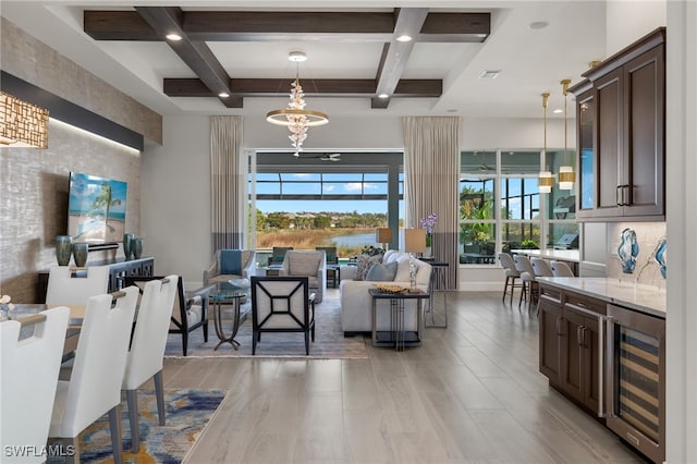 interior space featuring beam ceiling, wine cooler, a chandelier, and coffered ceiling