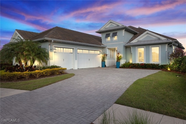 view of front of home featuring a garage and a yard