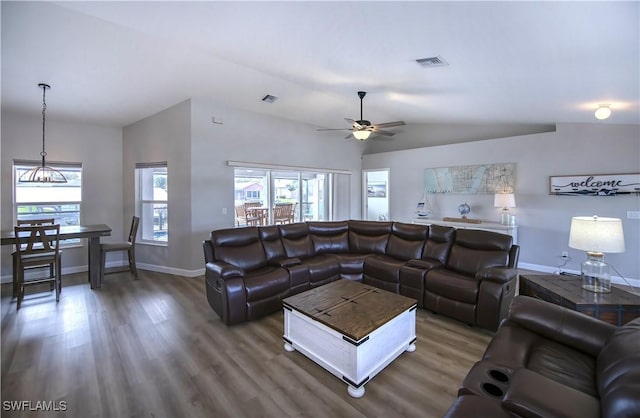 living room featuring vaulted ceiling, ceiling fan, and dark wood-type flooring