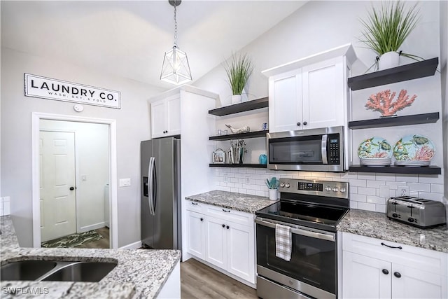 kitchen with white cabinets, pendant lighting, and appliances with stainless steel finishes