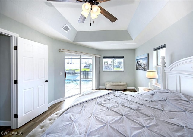 bedroom with a raised ceiling, ceiling fan, access to exterior, and dark wood-type flooring