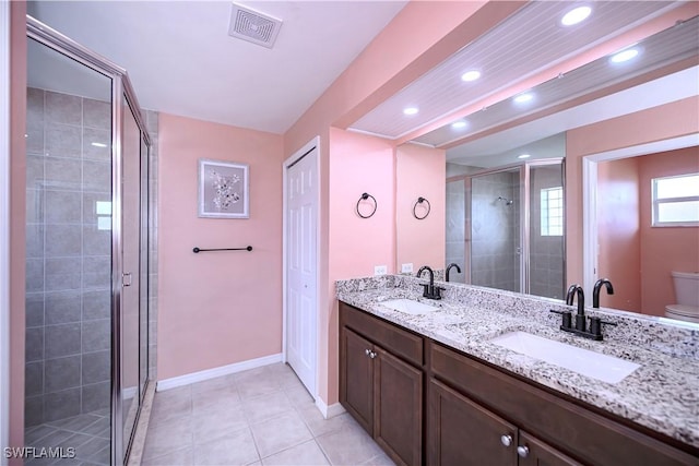 bathroom with vanity, a shower with door, tile patterned flooring, and toilet